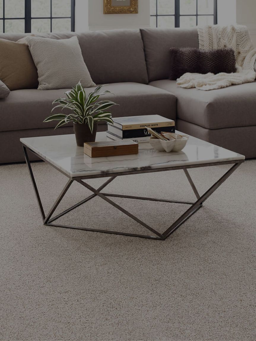 Woman sitting on a hardwood floor with a coffee mug in her hand.